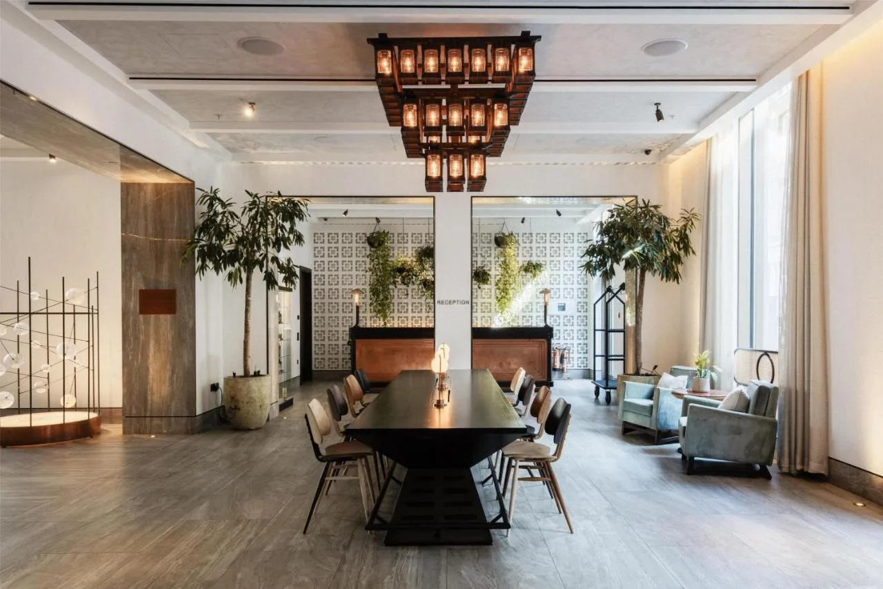 a lobby with a table and chairs in a room at Hart Shoreditch Hotel London, Curio Collection by Hilton in London